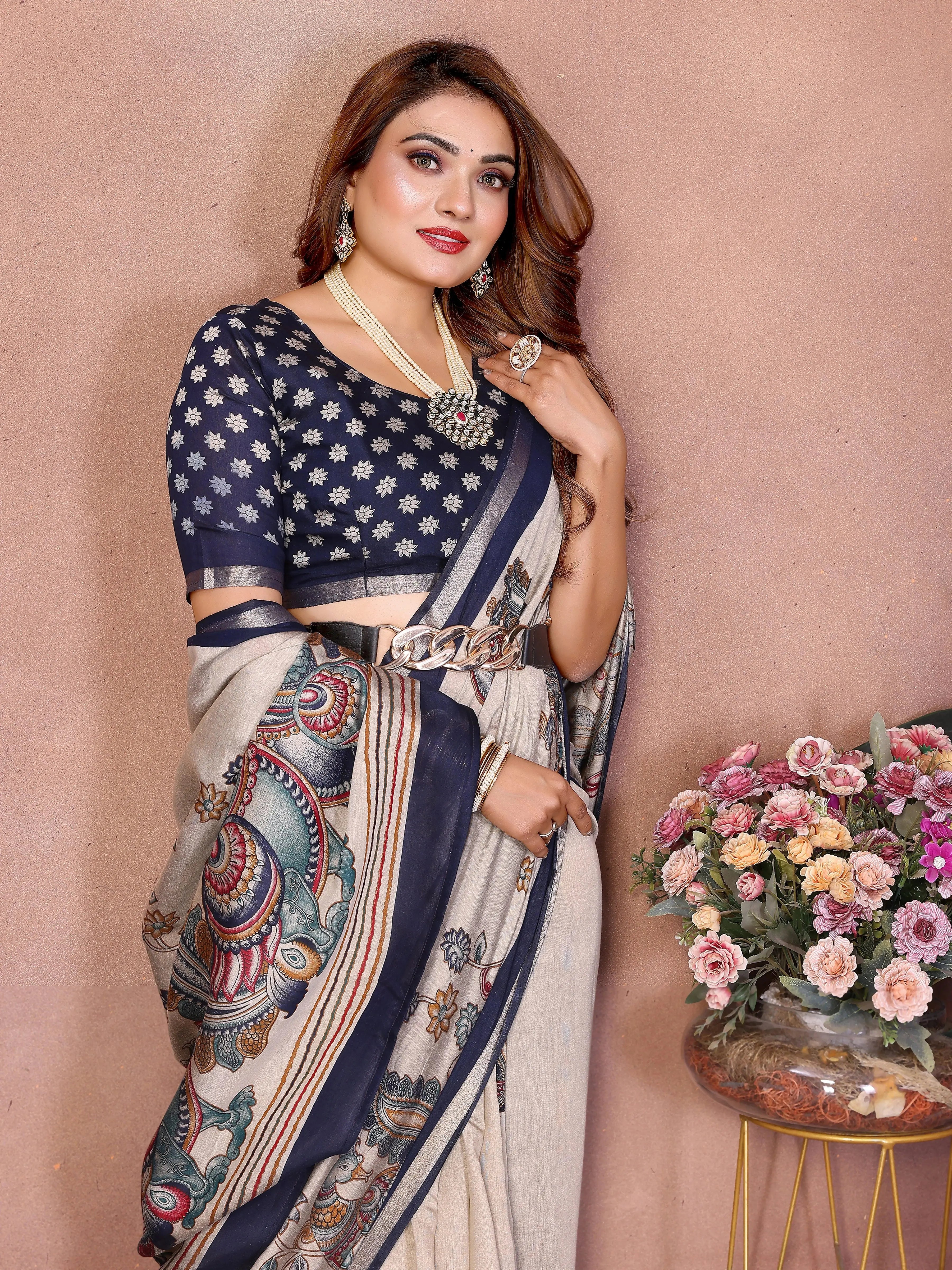 Woman in a saree with a floral arrangement on a pink background